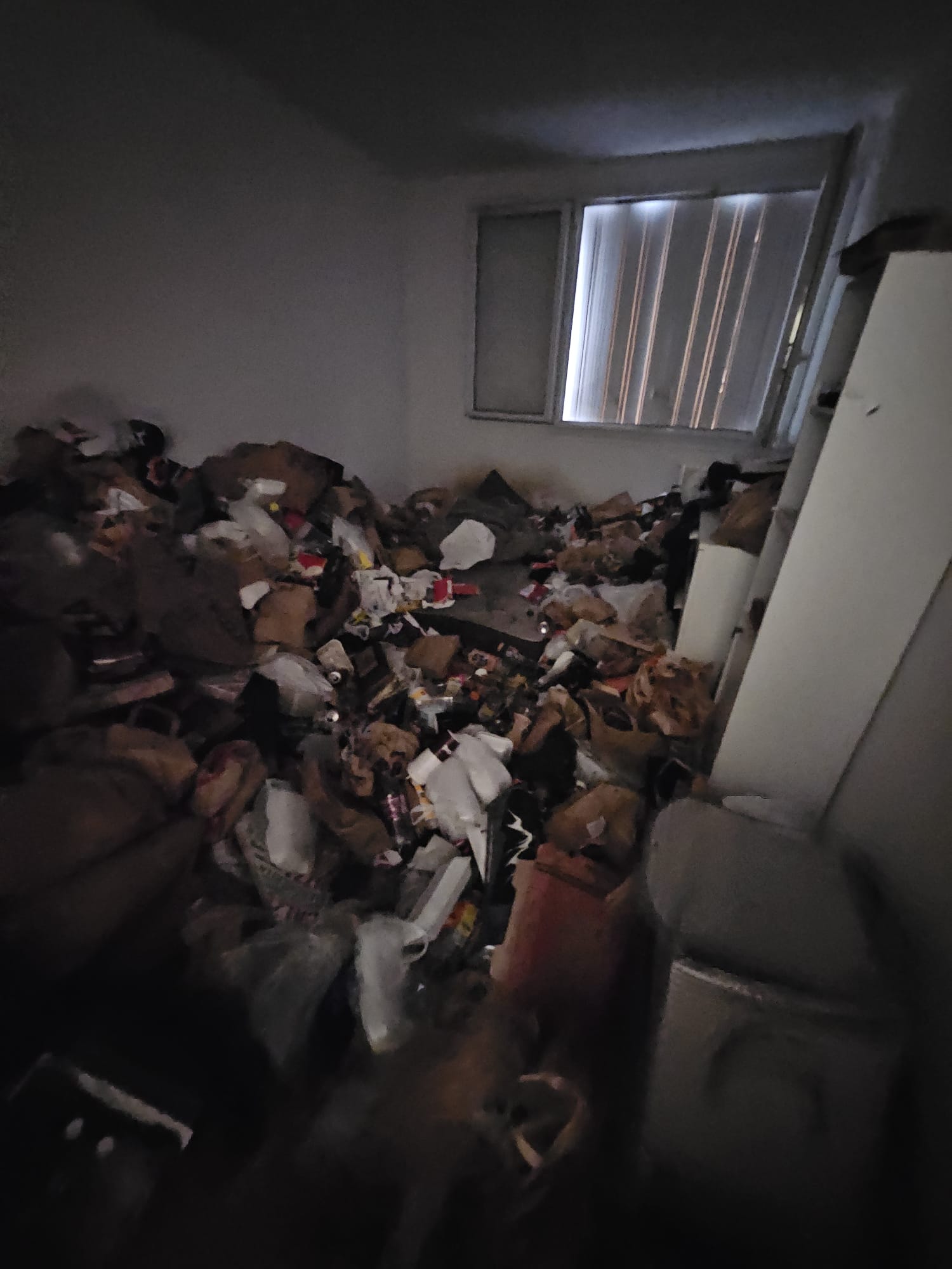 Pièce d'habitation entièrement encombrée, vue d'ensemble nocturne, intervention nécessaire