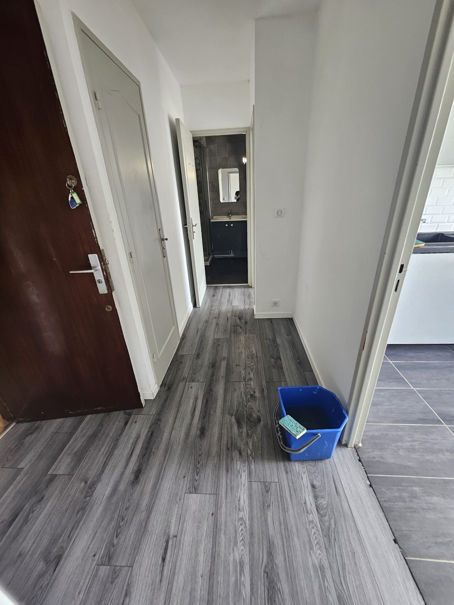 Même couloir après intervention Nettoyage Syndrome Diogène : passage entièrement libéré, parquet neuf, murs blancs, accès aux pièces rétabli